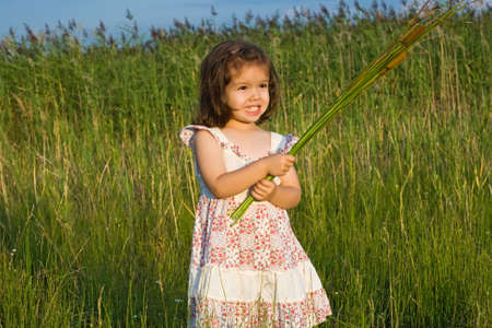 Happy little girl staying among the reedsの写真素材