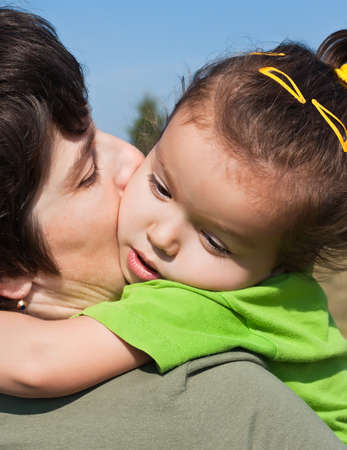 Little girl resting on her mother's shoulderの写真素材