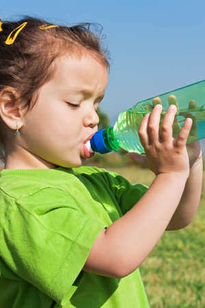 Little girl drinking fresh waterの写真素材