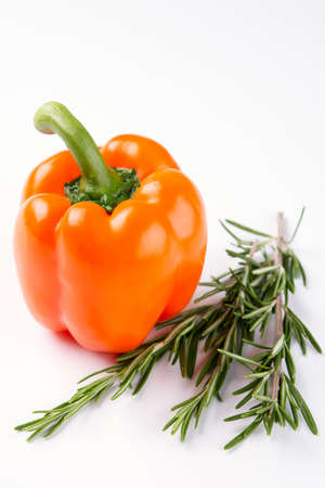 orange pepper with rosemary on whiteの写真素材