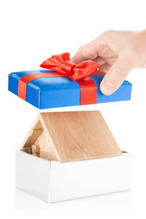 Small wooden house in a gift box with red bowの写真素材