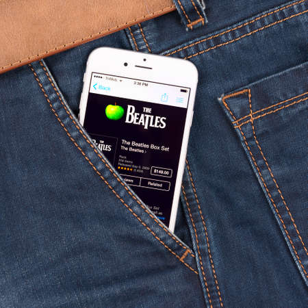SIMFEROPOL, RUSSIA - NOVEMBER 11, 2014: Apple iPhone 6 in jeans pocket displaying Beatles band music in iTunes. The Beatles were an English rock band that formed in Liverpool, in 1960.のeditorial素材