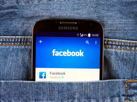 SIMFEROPOL, RUSSIA - NOVEMBER 11, 2014: Samsung Galaxy S4 in jeans pocket displaying Facebook application. Facebook is largest and most popular social networking site in the world.のeditorial素材