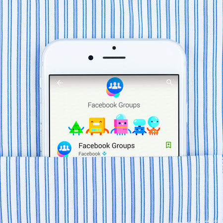 Simferopol, Russia - April 18, 2015: White Apple iPhone 6 in the pocket displaying Facebook groups application. Facebook is a social network service website launched on February 4, 2004