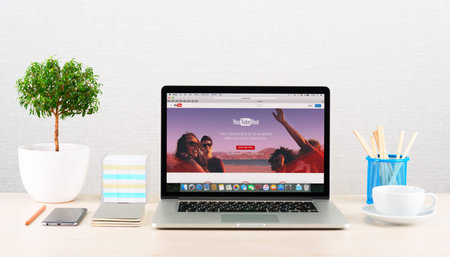 Moscow, Russia - January 30, 2016: Photo of modern workplace. Apple Macbook displaying Youtube red...