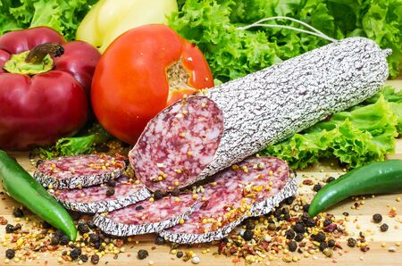 Still life with sliced romanian salami and vegetablesの写真素材