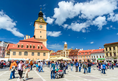 BRASOV ROMANIA  27 APRIL 2014: Scenery with tourists walking in Main Square landmark with Council House in medieval center of Brasov Transylvania Romania.のeditorial素材