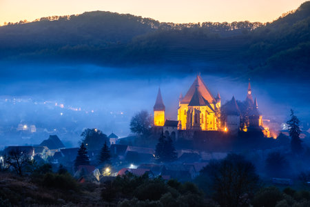 Biertan, Romania. Saxon village with the fortified church in Transylvania, mysty autumn fog landscape.のeditorial素材