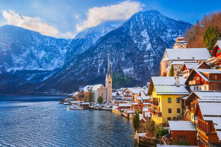 Hallstatt, Austria. Idyllic Alpine village snow-covered, serene lake, majestic mountains  and sunny winter charm.の写真素材
