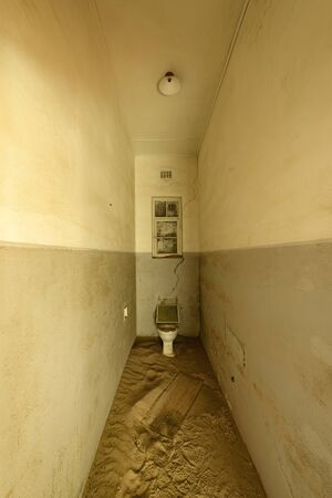 Narrow bathroom with a single toilet in a deserted building, Namibia.の写真素材
