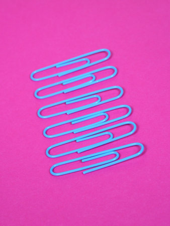 blue paper clips on pink background