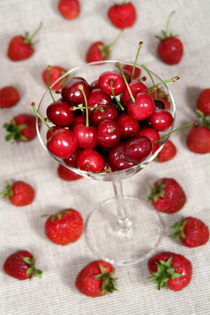 a glass of cherries between strawberriesの写真素材