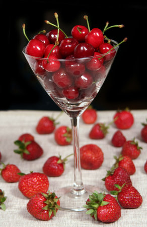 a glass of cherries between strawberriesの写真素材