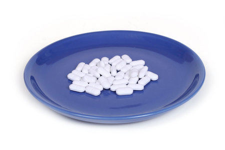 white pills on a blue plateの写真素材