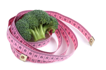 fresh broccoli and ping measure tape isolated on white backgroundの写真素材