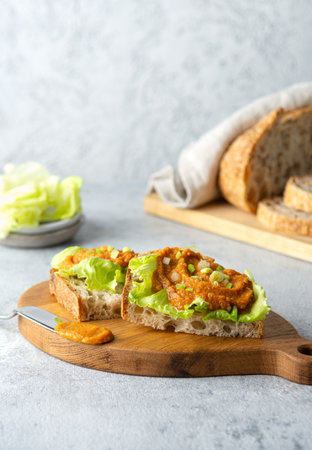 Fried bruschetta with vegetable zucchini caviar, lettuce and onion on a cutting board. Diet vegan food concept.の写真素材