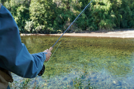 A woman fishing in a riverの写真素材