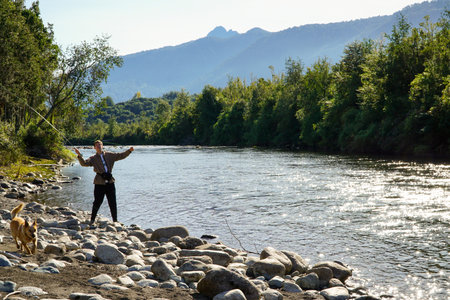 A young man fishing in a beautiful turquoise river in the south of Chileの写真素材