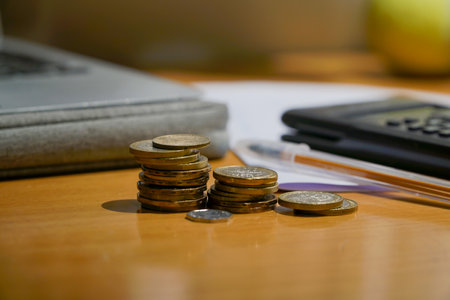 A pile of coins on a wooden table representing the rise of the prices. concept of inflationの写真素材