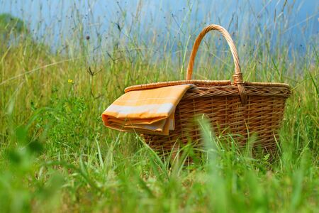 Picnic basket and table cloth on a meadowの写真素材