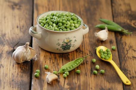 Green peas and garlic on the kitchen tableの写真素材