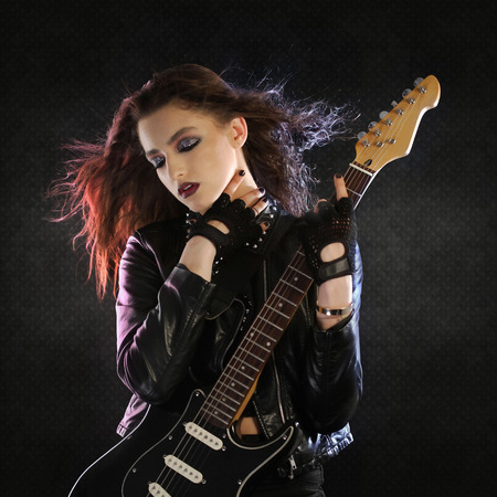 Rock star posing with her guitarの写真素材