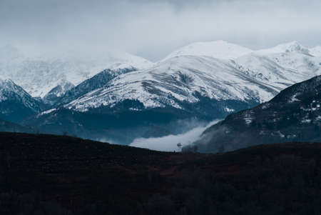 Clouds are low in front of mountains covered with snow in Pyreneesの写真素材