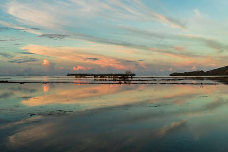 Reflections in the water of a sunrise on an islandの写真素材