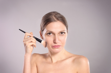 Young woman putting make-upの写真素材