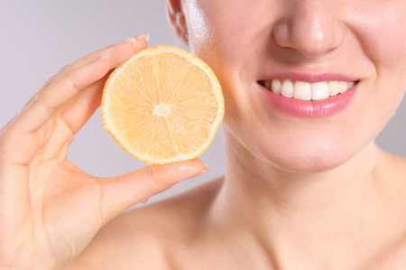 Beautiful young woman with lemons. Healthy food concept. Skin care and beauty. Vitamins and minerals.の写真素材