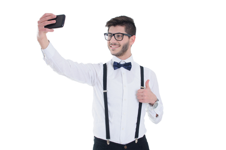 Young man making selfie and smiling, isolated on white backgroundの写真素材
