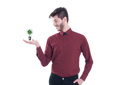Copy space on his hand. Handsome young man in shirt holding ecology symbol while standing against white backgroundの写真素材