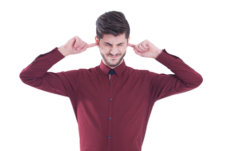 Unhappy, stressed man covering his ears and closing his eyes. Isolated on white backgroundの写真素材