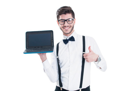 Young beautiful man holding laptop with blank screen and making the ok gesture. Isolated on white backgroundの写真素材