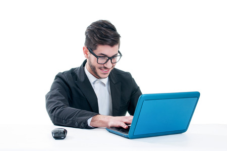 Smiling young man chatting on his laptop. Isolated on white backgroundの写真素材