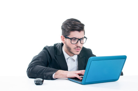 Young business man looking at his laptop with disappointment. Isolated on white backgroundの写真素材