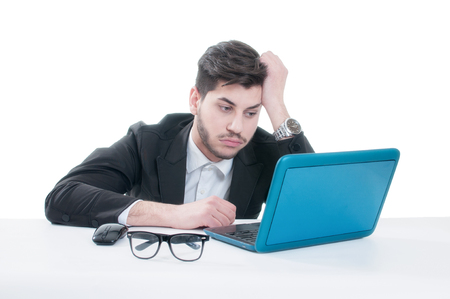 Young business man looking at his laptop with disappointment. Isolated on white backgroundの写真素材