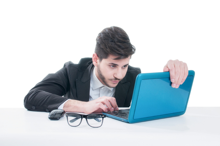Young business man looking at his laptop with disappointment. Isolated on white backgroundの写真素材
