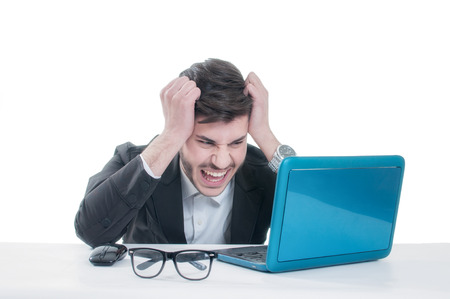 Angry young businessman with problems and stress at his workplace. Isolated on white backgroundの写真素材