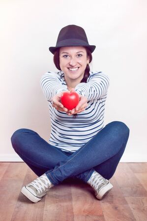 happiness, love and health concept - woman with red heartの写真素材