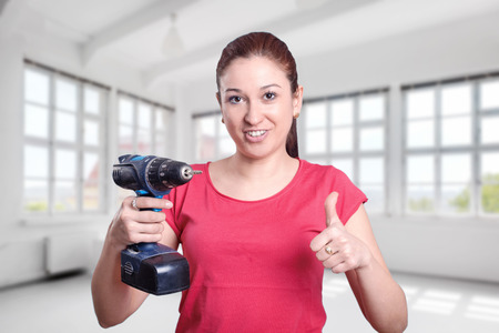 Young woman with a electric drillの写真素材