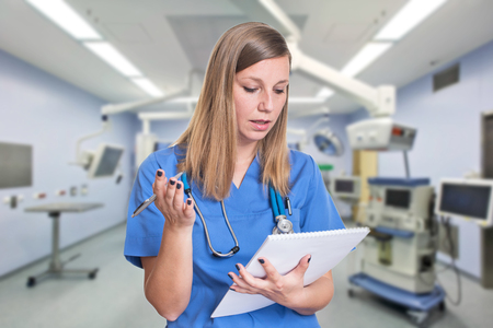 Shocked woman doctor reading her clipboardの写真素材