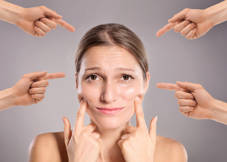 Concept of guilty person woman. Sad upset woman with many fingers pointing at herの写真素材