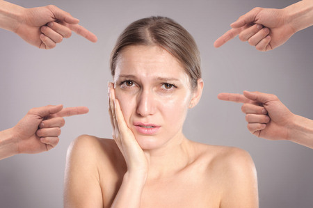 Concept of guilty person woman. Sad upset woman with many fingers pointing at herの写真素材