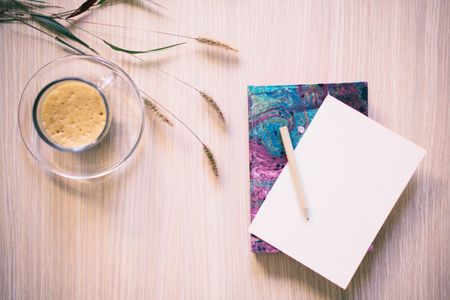 Coffee and notebook on wooden tableの写真素材