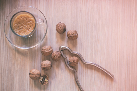 Walnuts and coffee on old wooden tableの写真素材