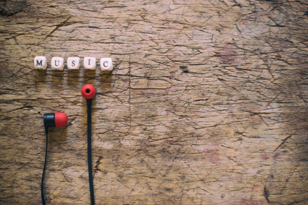 Word Music and earphones on wooden tableの写真素材