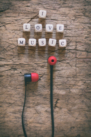 Word I Love Music and earphones on wooden tableの写真素材