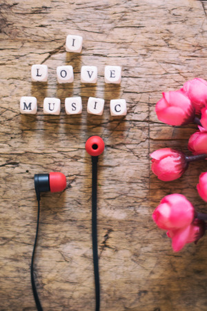 Word I Love Music and earphones on wooden tableの写真素材