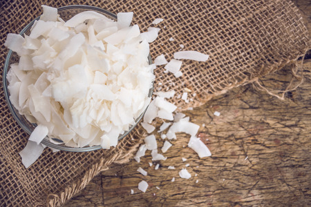 Dried coconut flakes on wooden backgroundの写真素材